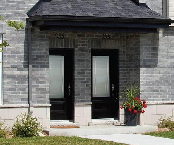 Residential brick home with black entrance doors